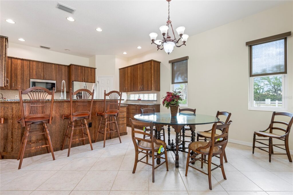 Bright kitchen with wooden cabinets and a dining table with chairs.