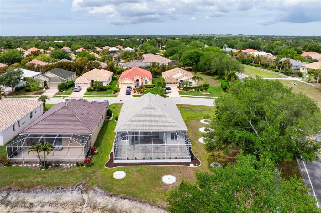 Aerial view of suburban homes with screened pools and lush greenery.