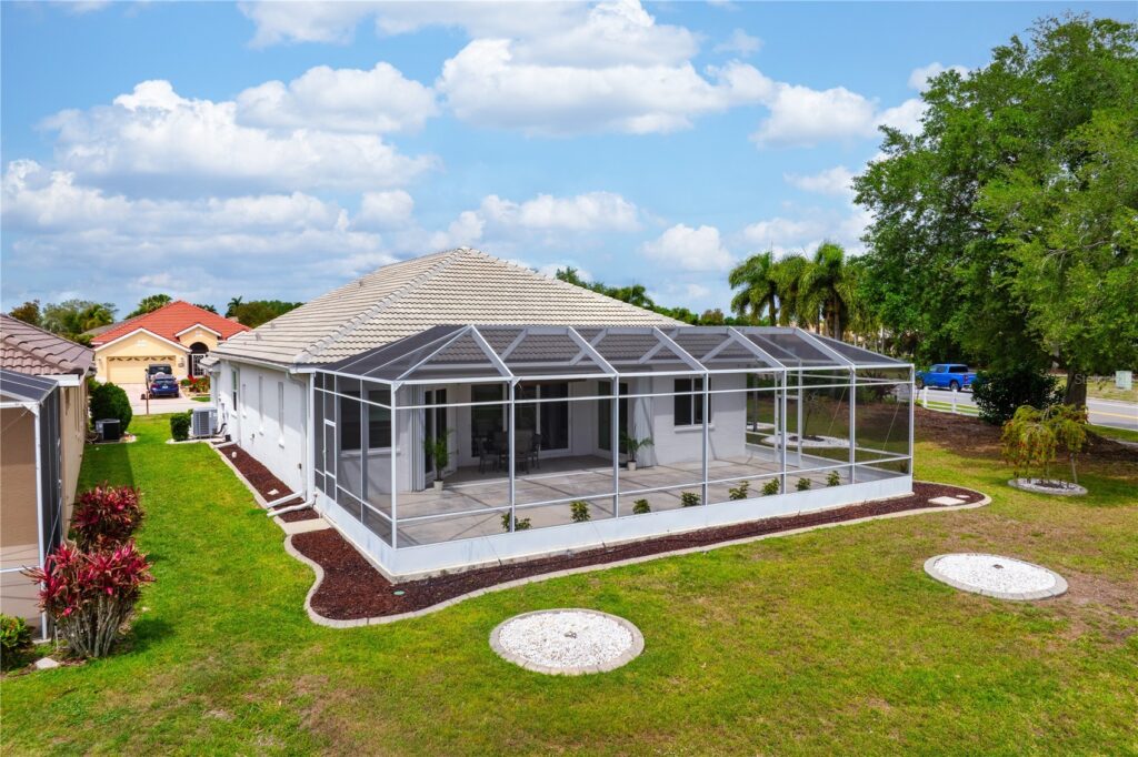 Modern house with a large screened patio under a partly cloudy sky.