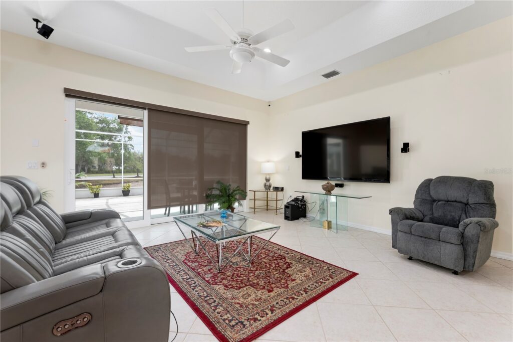 Modern living room with gray seating and a red rug.