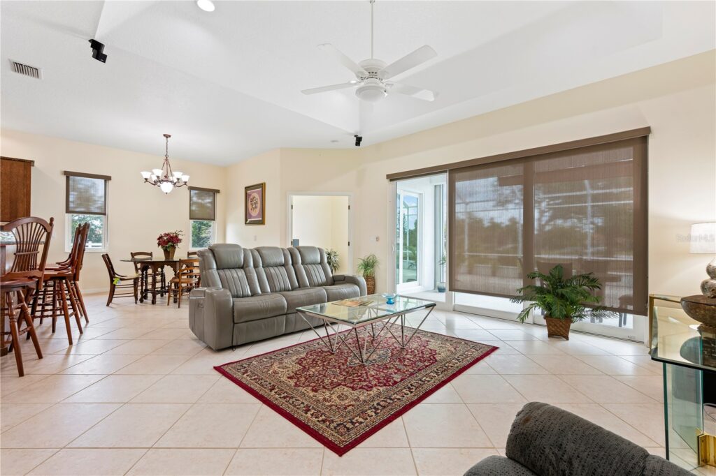 Bright living room with gray sofas and a patterned rug.