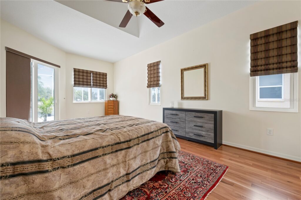 Cozy bedroom with striped bedspread and wooden furniture.
