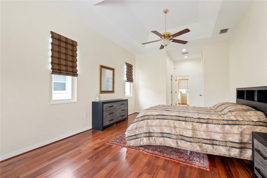 Cozy bedroom with wooden floors and plaid bedding.