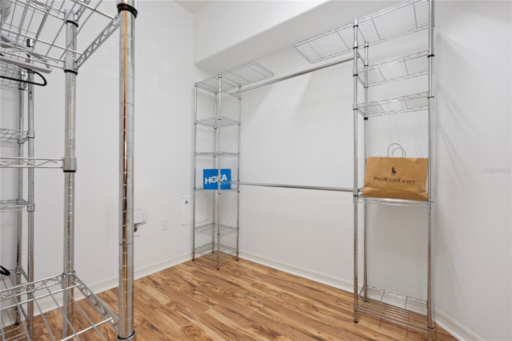 Empty metal shelving unit with wooden and plastic shelves in a room.