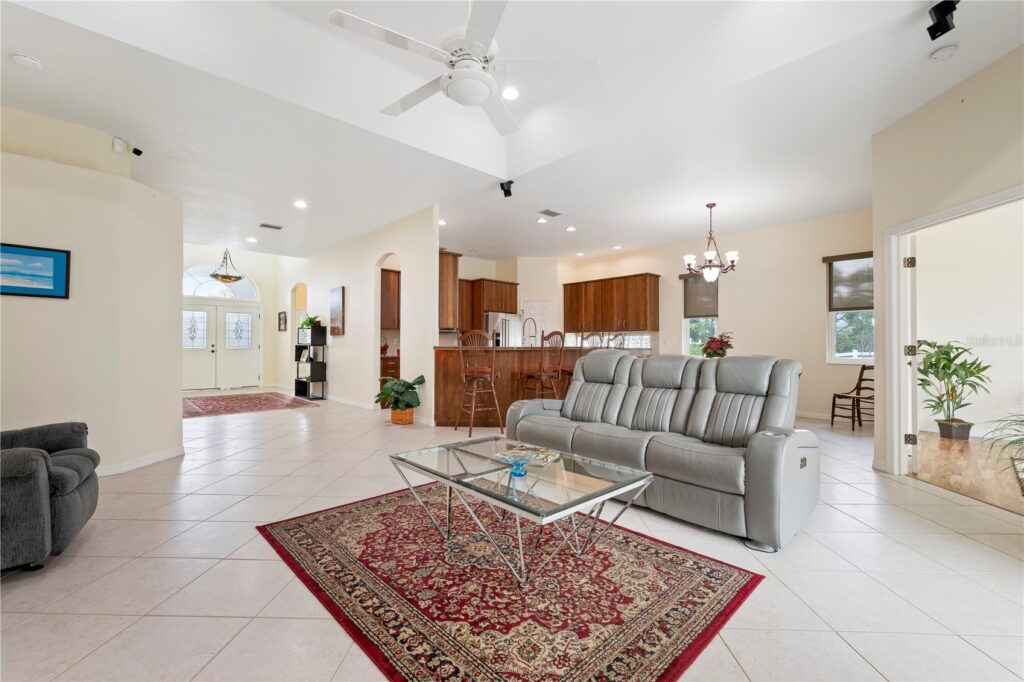 Spacious living room with leather sofas and a red patterned rug.