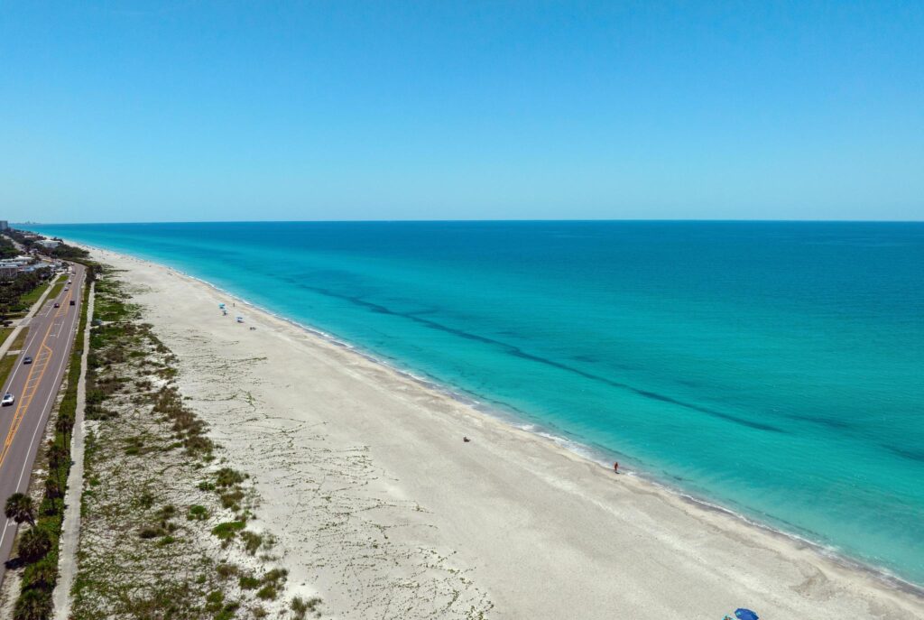 Pristine beach with turquoise water under a clear blue sky.