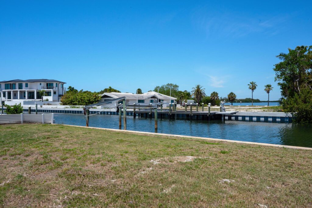 Waterfront houses with docks under a clear blue sky.