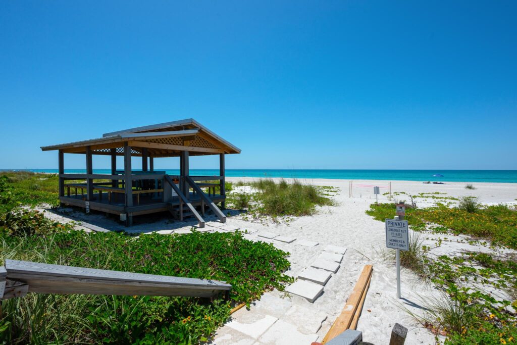 A peaceful beach gazebo overlooking white sand and turquoise water.