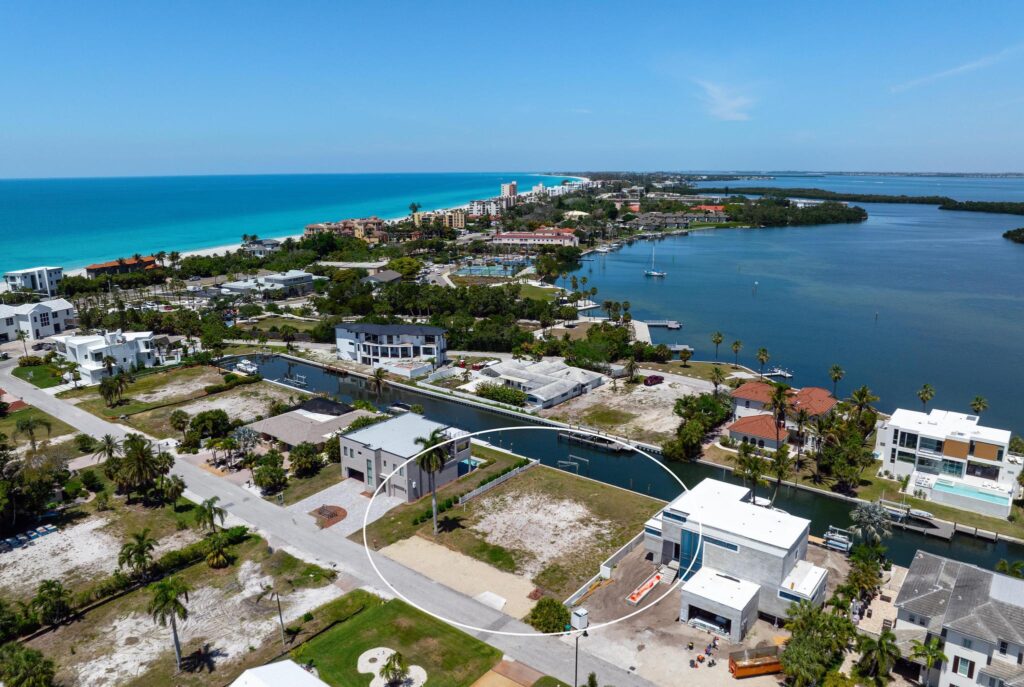 A coastal town with a bridge over turquoise waters under a clear blue sky.