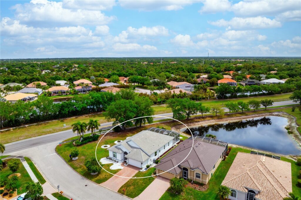 A suburban neighborhood with houses and a waterway under a blue sky.